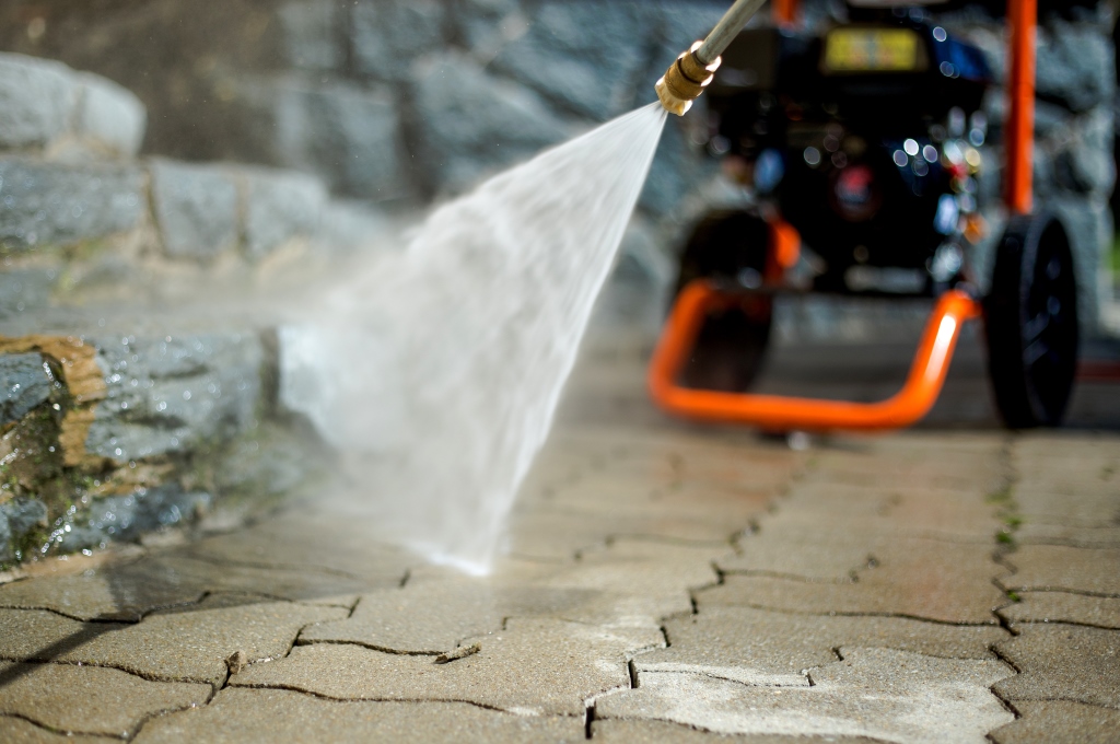 A fire hydrant spewing water onto a sidewalk